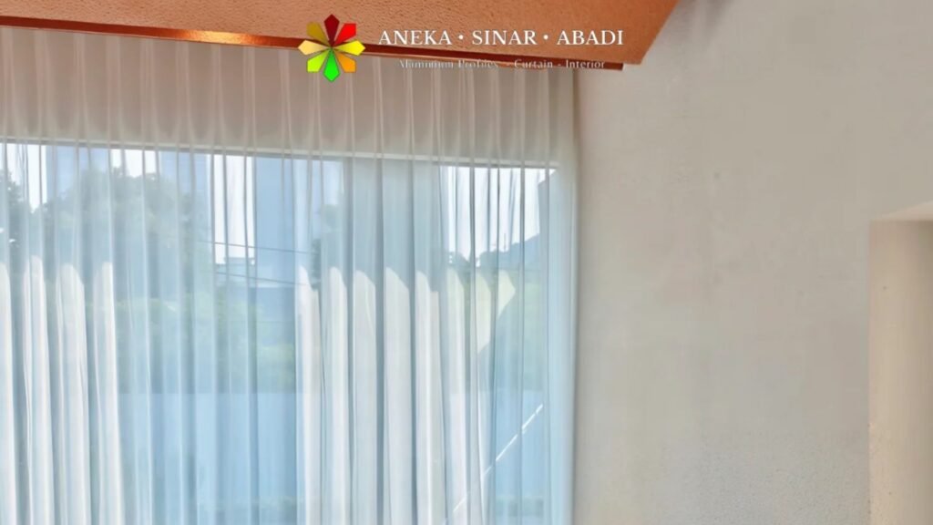 Sheer curtain custom putih dari plafon hingga lantai pada jendela kaca lebar menghadap pepohonan