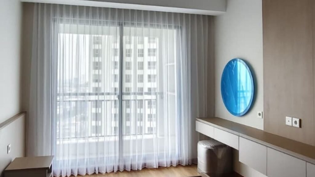 Supplier Vitrase Hotel Custom / Gorden Sheer custom putih dari plafon hingga lantai pada pintu kaca balkon kamar dengan pemandangan gedung tinggi